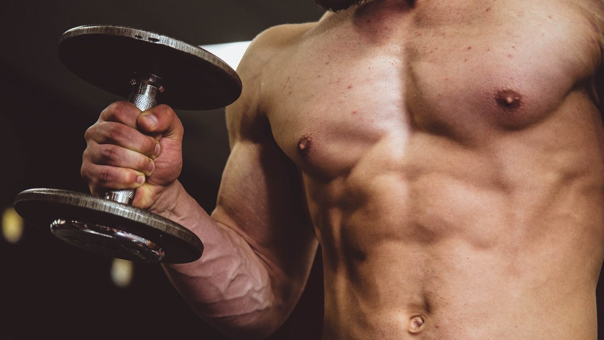 man holding black dumbbell